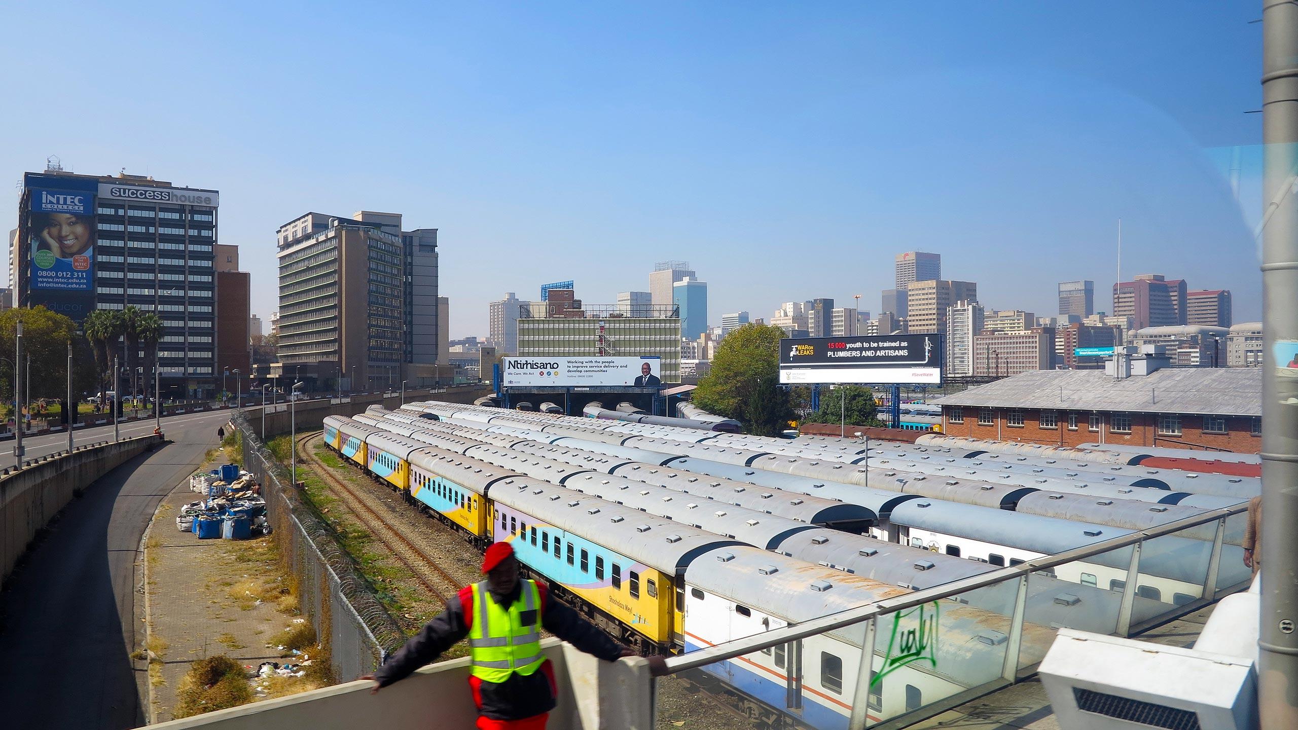 Man schaut auf der Nelson-Mandela-Brücke über den Rangierbahnhof direkt auf die Skyline von Johannesburg
